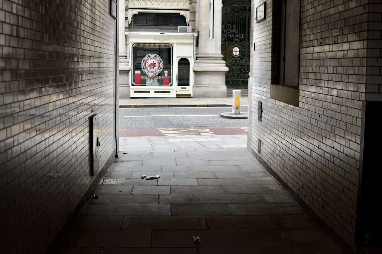 View through a brick-lined passageway towards the Royal Exchange building in London
