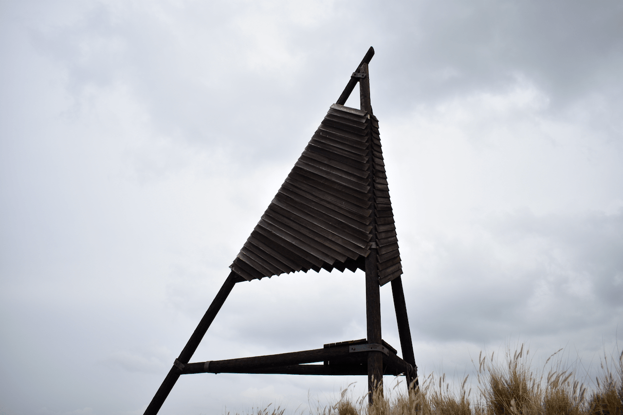 Wooden triangular structure against a cloudy sky